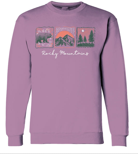 Purple sweatshirt with 'Rocky Mountains' design featuring a bear, mountains, and trees on a light purple background.
