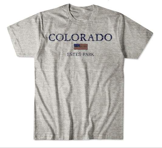 A heather gray short-sleeve t-shirt with a distressed navy blue 'COLORADO ESTES PARK' graphic and a small American flag on the chest, shown below a color/material specification panel.