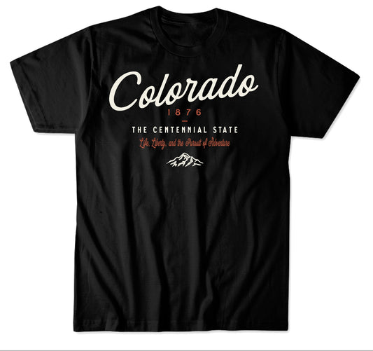 A black short-sleeve graphic T-shirt displayed on a white background below a black informational header. The header reads 'Colorado 1876 The Centennial State' with decorative text and a mountain icon.