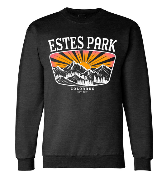 A dark charcoal crewneck sweatshirt with a large 'Estes Park Colorado' mountain graphic on the chest, shown both as a flat product preview and on a torso mannequin-style mockup. The graphic features white text and mountains with orange and yellow sunburst rays.